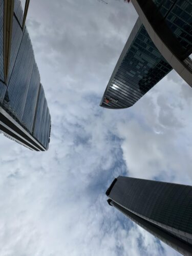 Dynamisch perspectief omhoog naar de drie wolkenkrabbers van CityLife Milaan—Allianz Tower, Generali Tower en PwC Tower—iconische skyline in het autovrije stadsdeel.